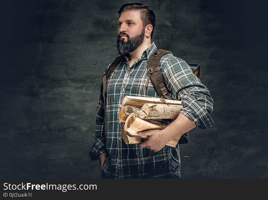 Fat bearded male holds fire woods over grey background. Fat bearded male holds fire woods over grey background.