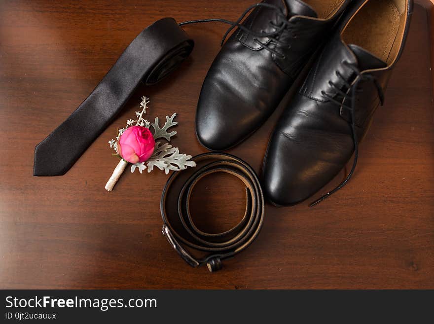 Groom’s accessories: flower boutonniere, leather belt, necktie, shoes. Wedding