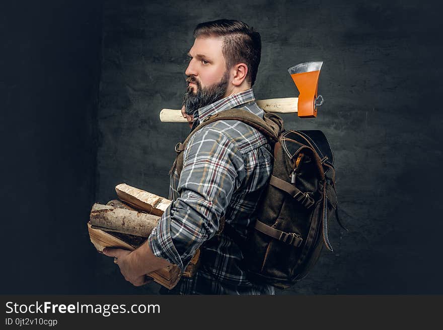 Portrait of brutal bearded hunter male holds an axe on his shoul