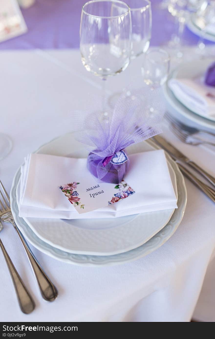 A wedding purple bonbonniere in a shape of heart lying on a white plate