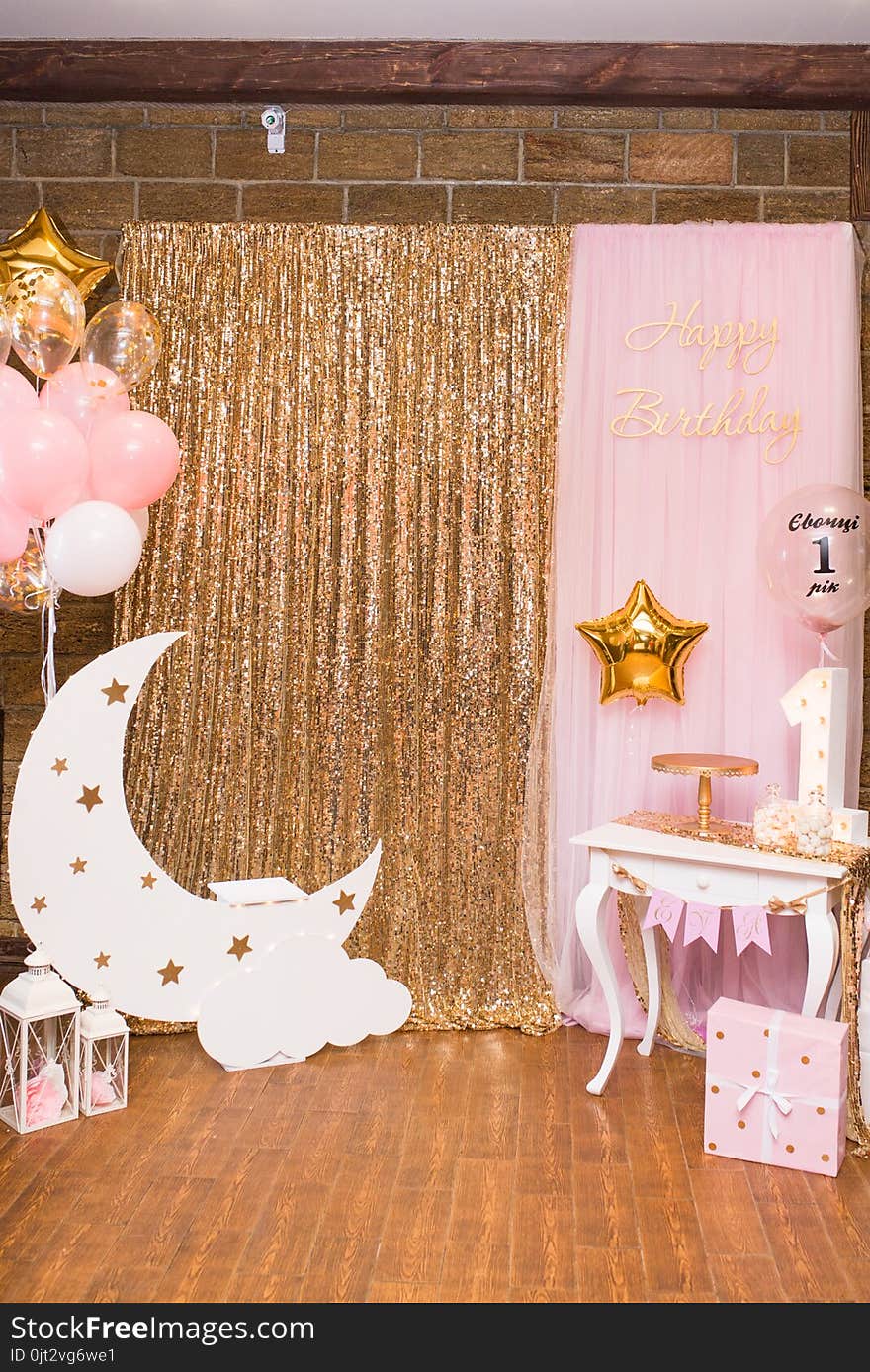 Children`s photo zone with a wooden month with stars and a lot of balloons. Decorations for a One year old Girl’s Birthday .