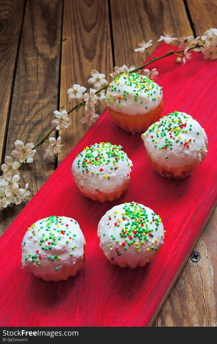 Easter colorful cupcakes on wooden table. Easter cupcakes and a cherry twig