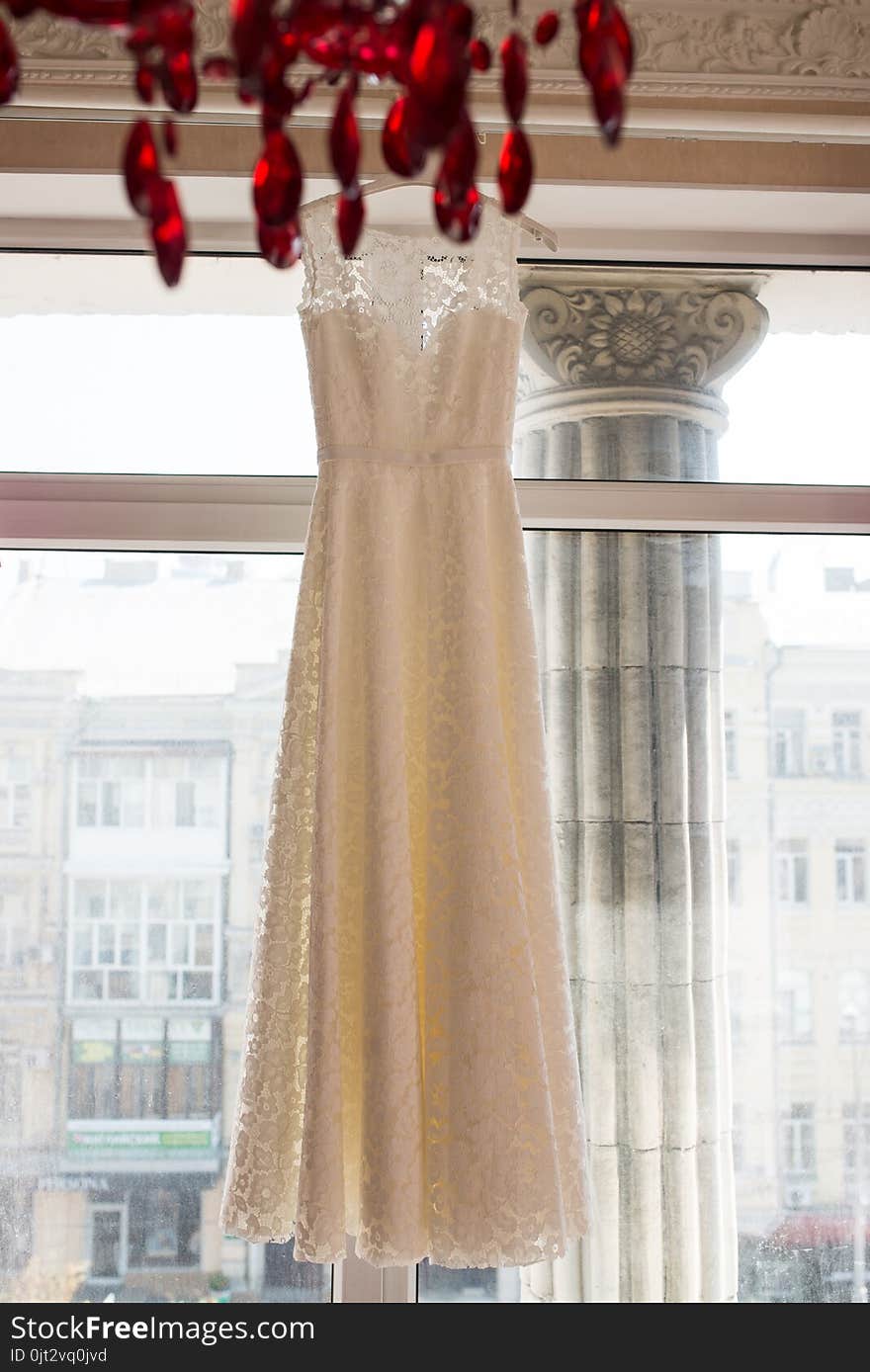 Wedding dress on hanger on a window. Beautiful gown.