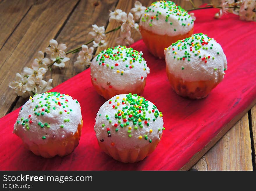 Easter colorful cupcakes on wooden table. Easter cupcakes and a cherry twig