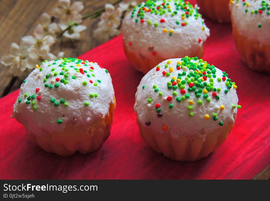 Easter colorful cupcakes on wooden table. Easter cupcakes and a cherry twig