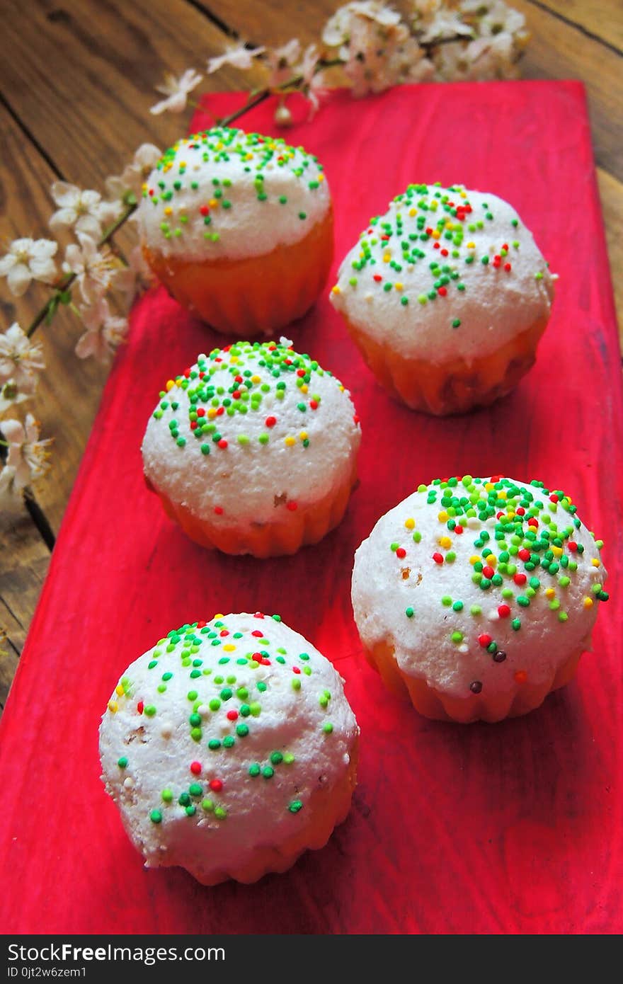 Easter colorful cupcakes on wooden table. Easter cupcakes and a cherry twig