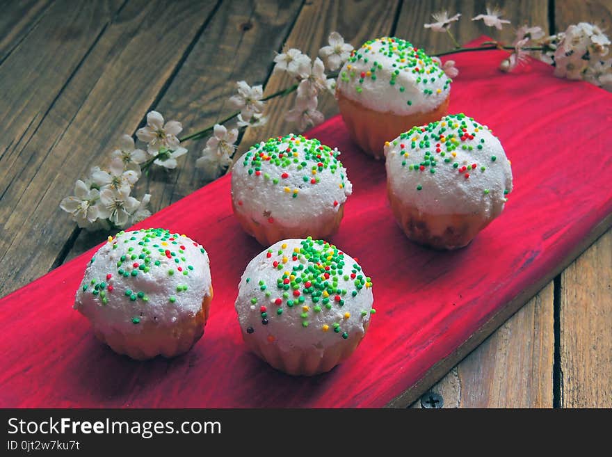 Easter colorful cupcakes on wooden table. Easter cupcakes and a cherry twig