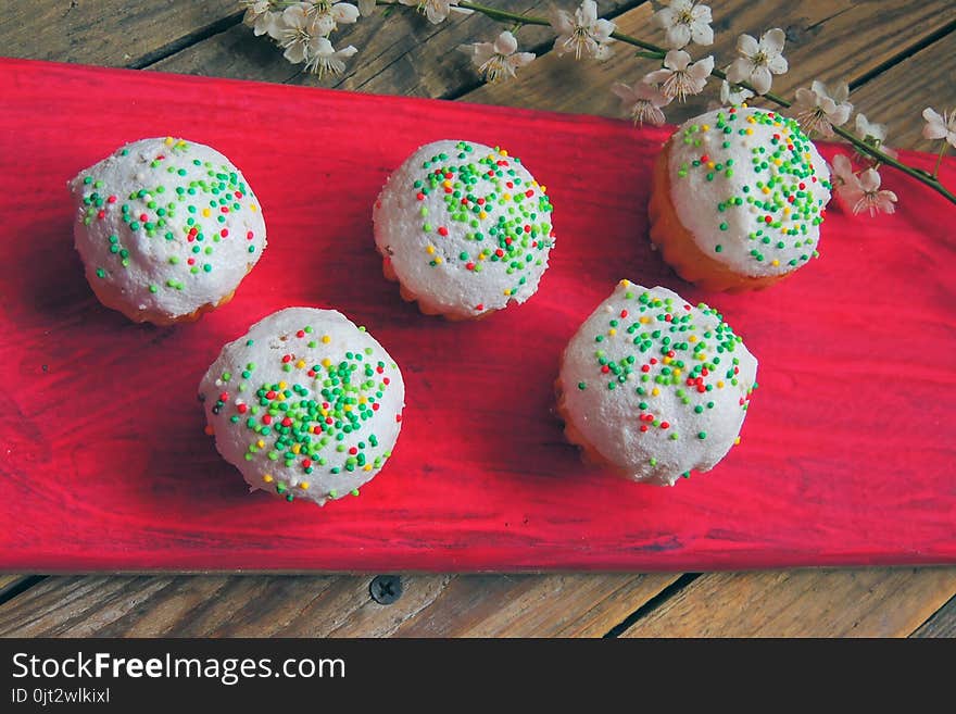 Easter colorful cupcakes on wooden table. Easter cupcakes and a cherry twig