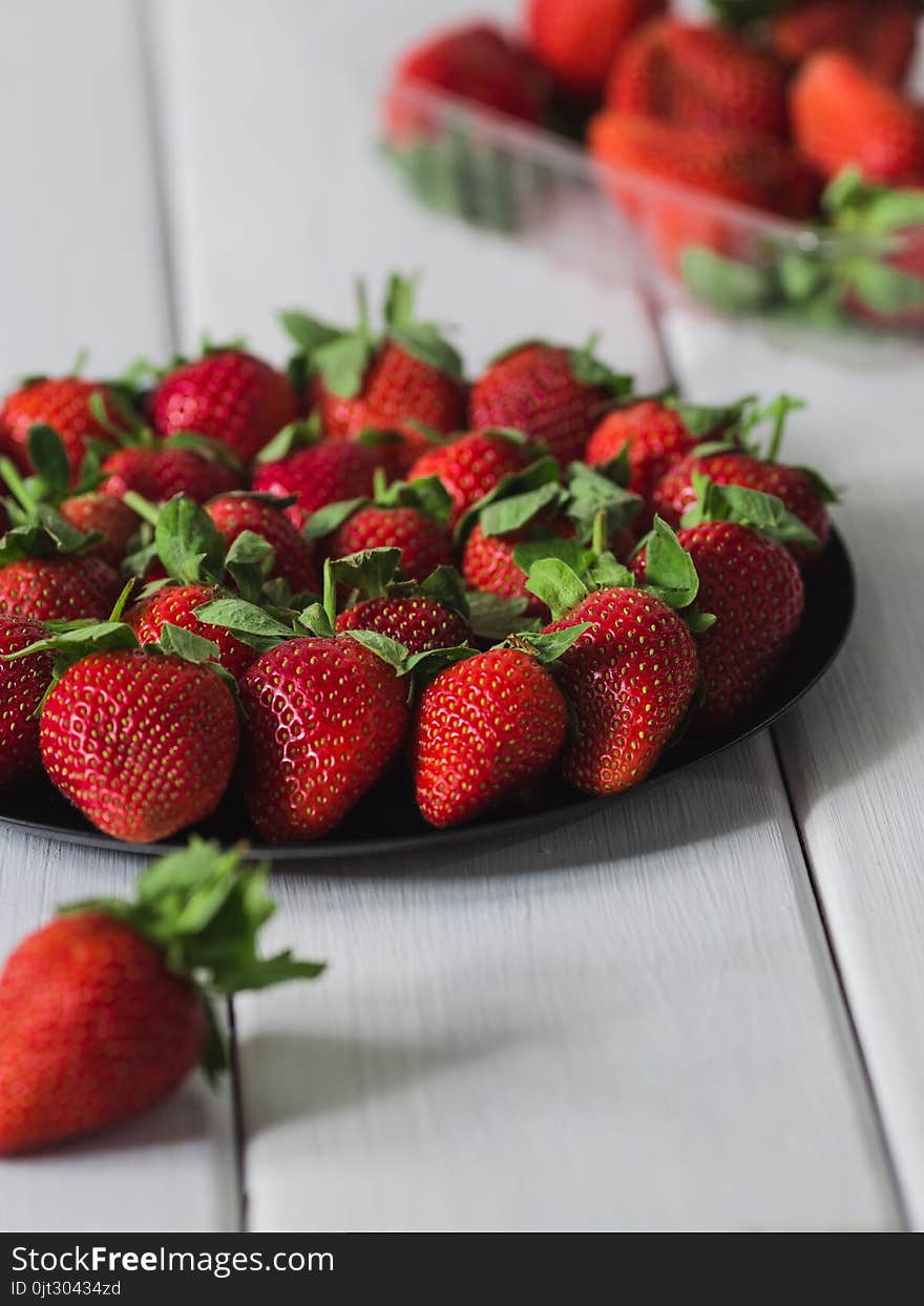 Lots of strawberries in a still life on a white background, summer garden wooden white table