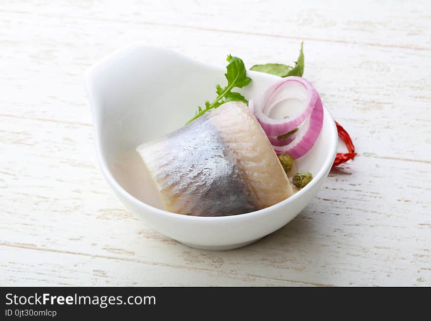 Herring fillet served onion and salad leaves