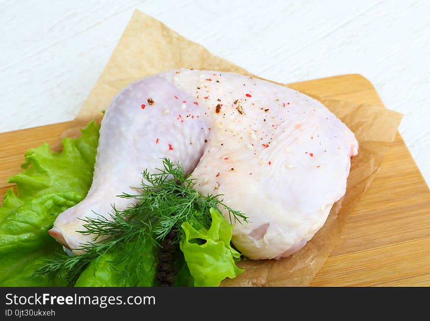 Raw chicken leg with herbs and spices ready for cooking