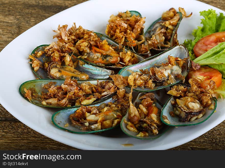 Fresh Mussels with fried garlic served tomato, salad and cucumber. Fresh Mussels with fried garlic served tomato, salad and cucumber