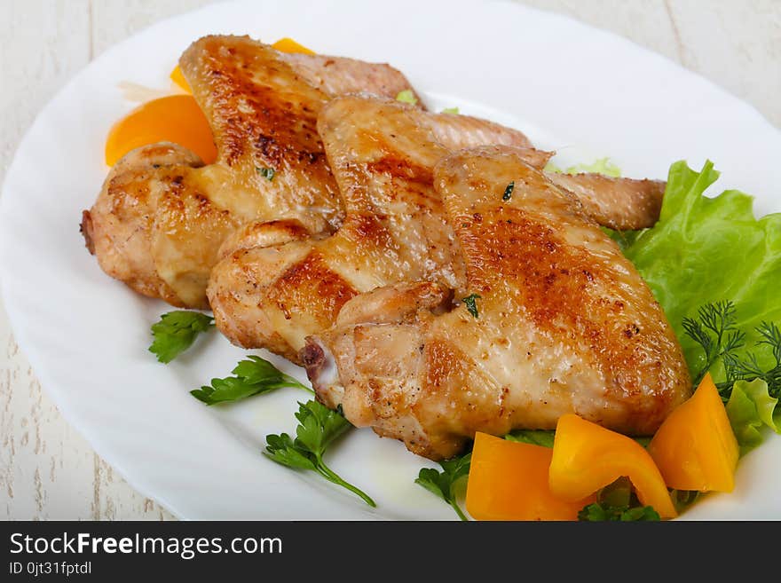 Roasted Chicken wings served salad leaves and parsley