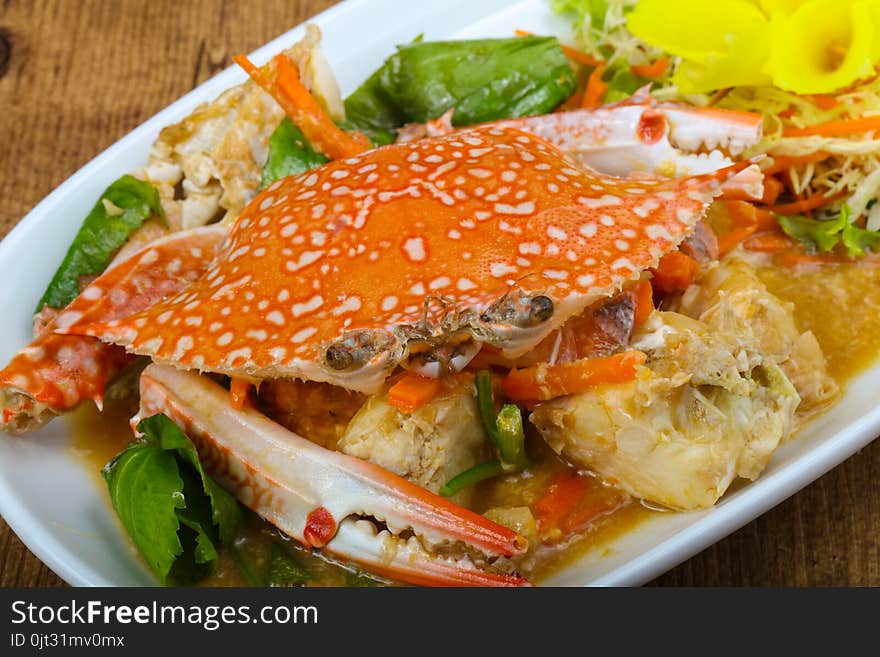 Boiled crab with sauce on wood background