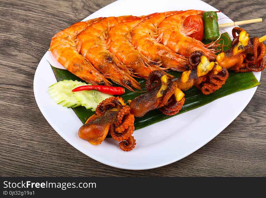 Skewer with octopus and prawn on banana leaves