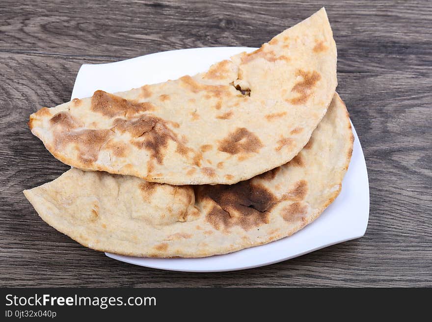 Indian bread naan in the plate on wood background