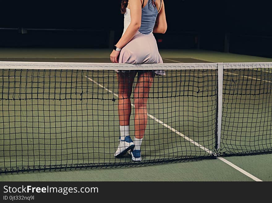 female tennis player posing on a tennis court.