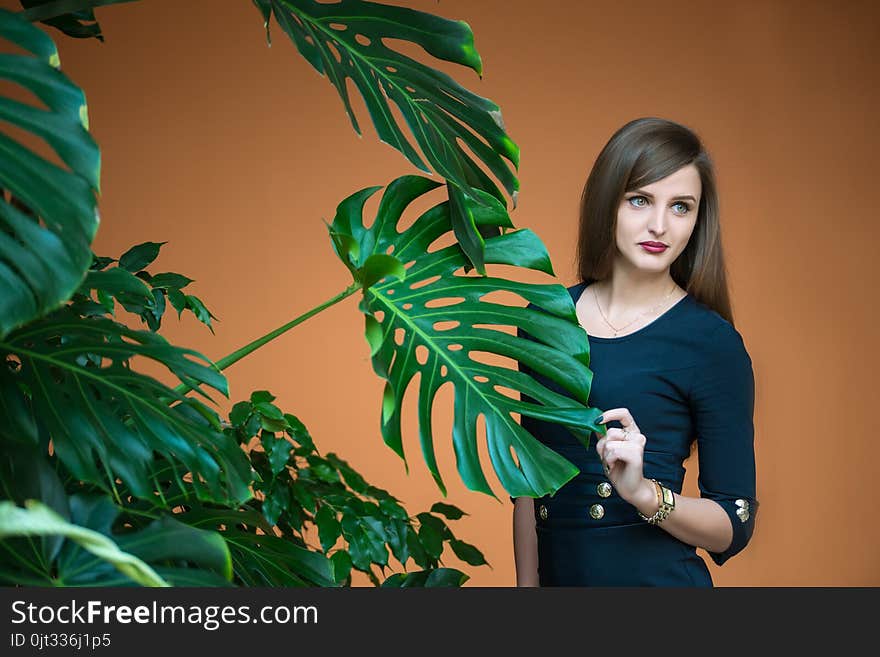 Pretty girl holding by hand stalk of palm