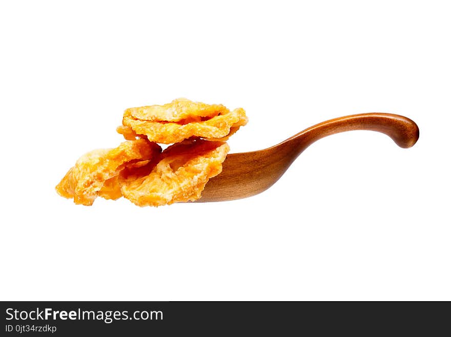 Dried pineapples slices in the wooden spoon, isolated on white background.