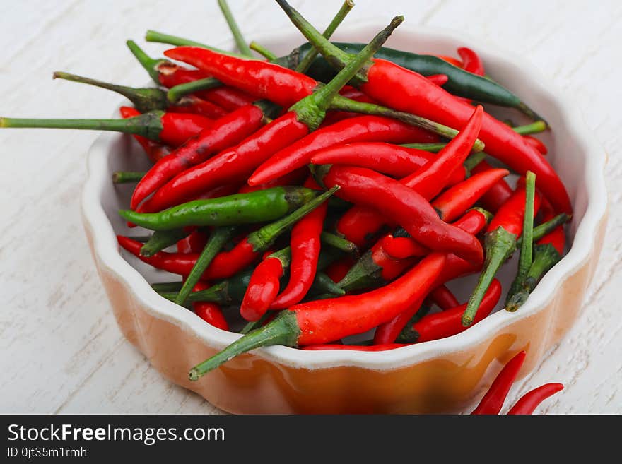 Hot chili pepper heap on the wood background