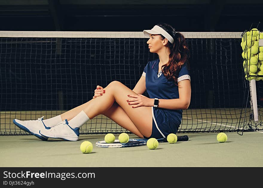 Female Tennis Player Posing On A Ground In A Court.