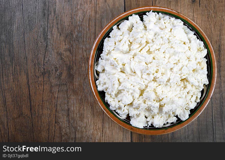 Homemade cottage cheese in a bowl on wooden table .close-up. Homemade cottage cheese in a bowl on wooden table .close-up