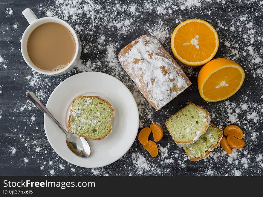 Mint Cake Sprinkled With Powdered Sugar On Dark Surface With Fresh Oranges Mandarins.