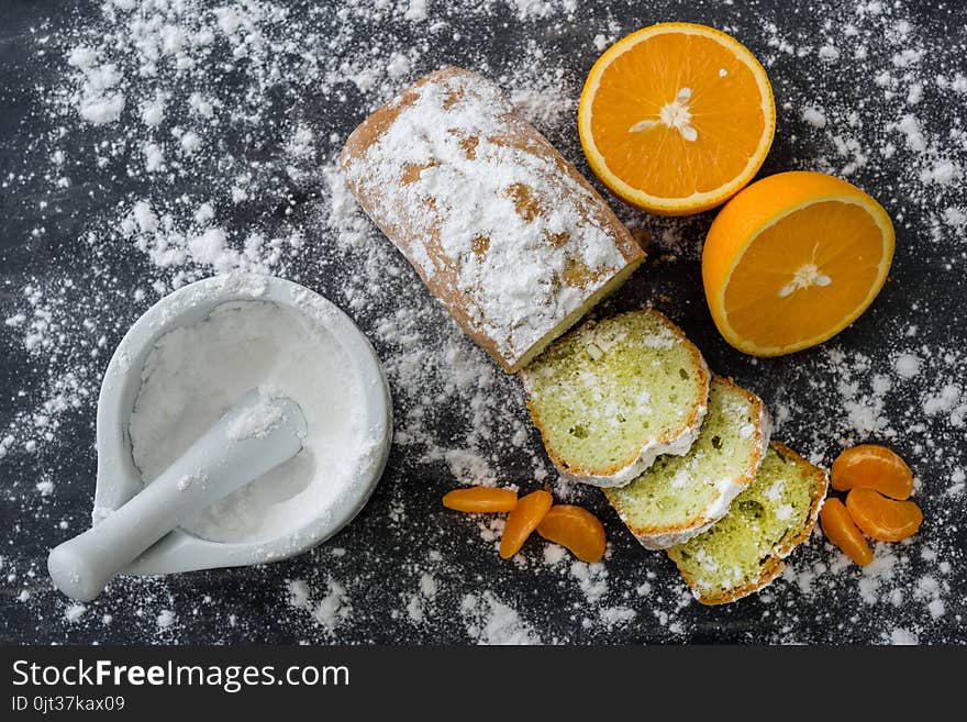 Mint Cake Sprinkled With Powdered Sugar On Dark Surface With Fresh Oranges Mandarins.