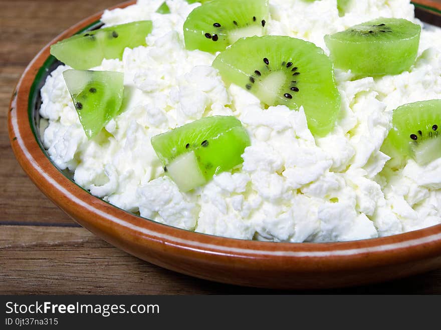 Homemade cottage cheese in a bowl on wooden table.