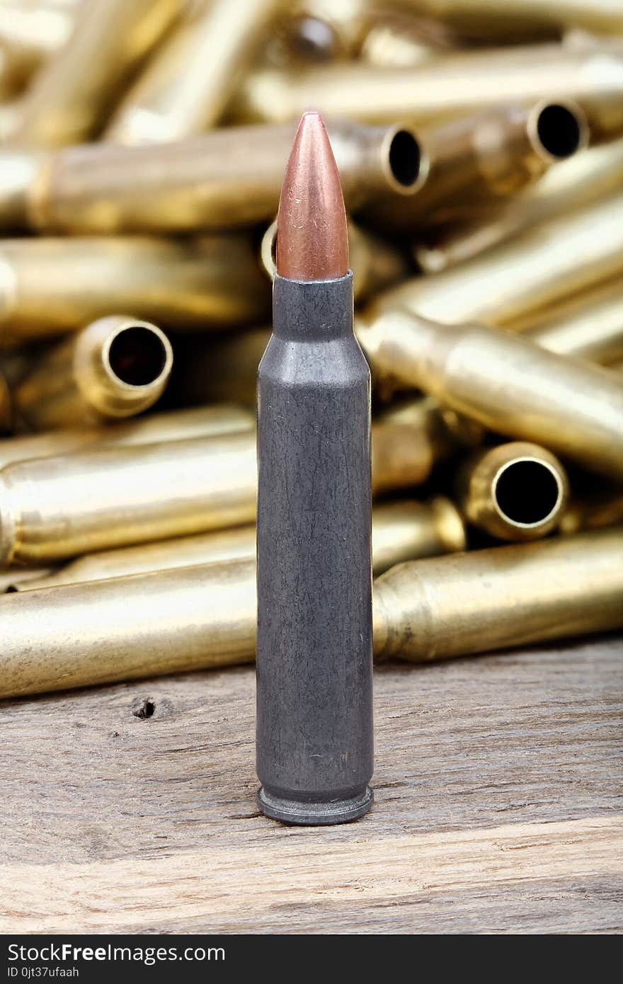 Close-up photo of bullet on the wooden table.