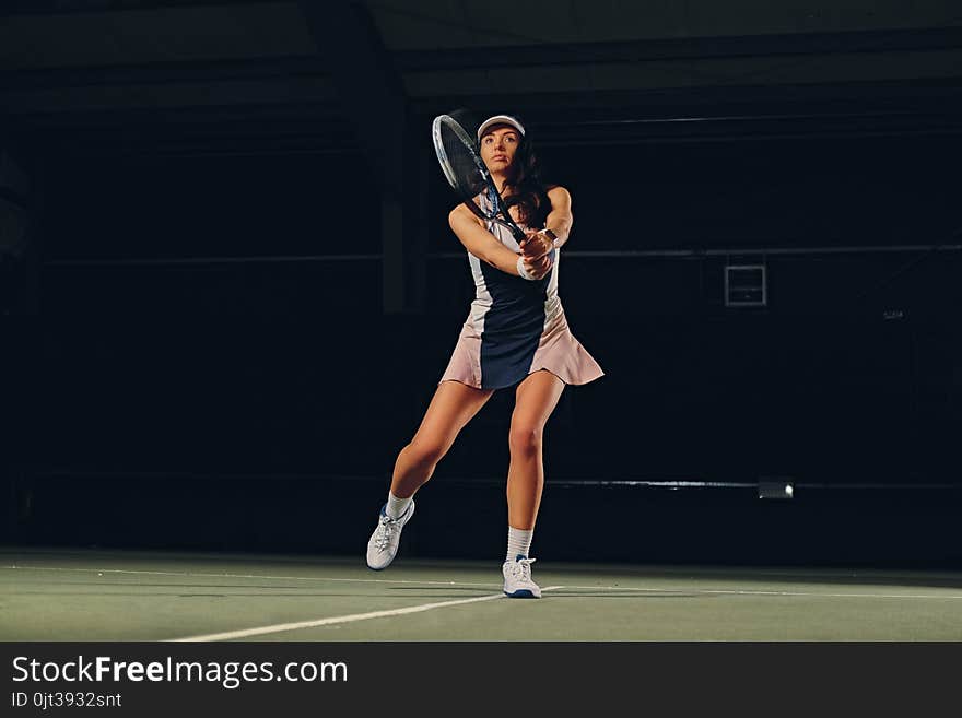 Female Tennis Player In A Jump On A Tennis Court.