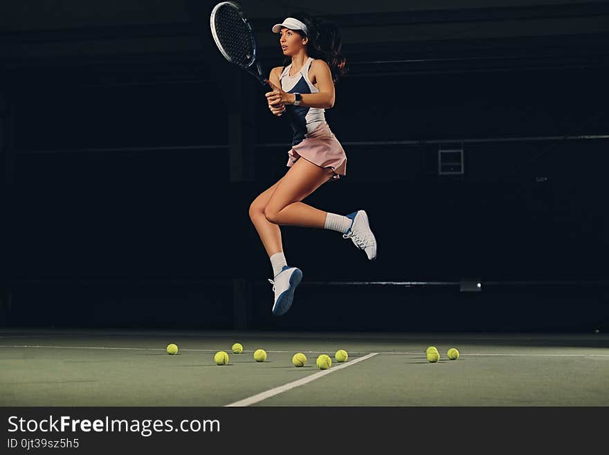 Female Tennis Player In A Jump On A Tennis Court.