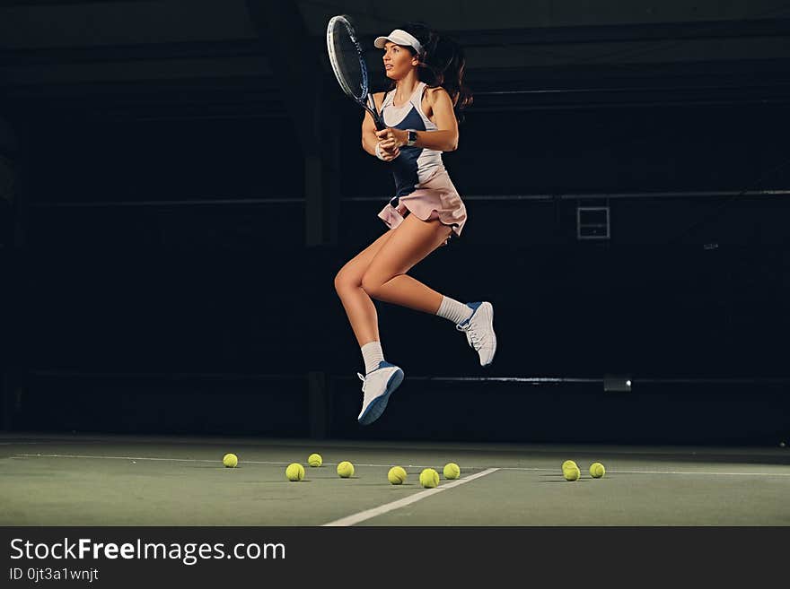 Female tennis player in a jump on a tennis court.