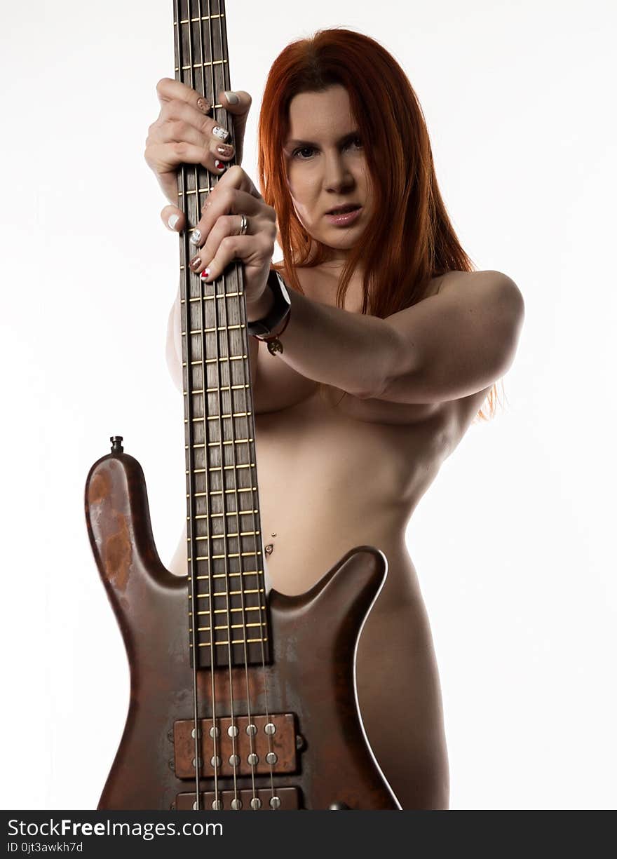 Nude rock woman holding electric guitar on a white background.