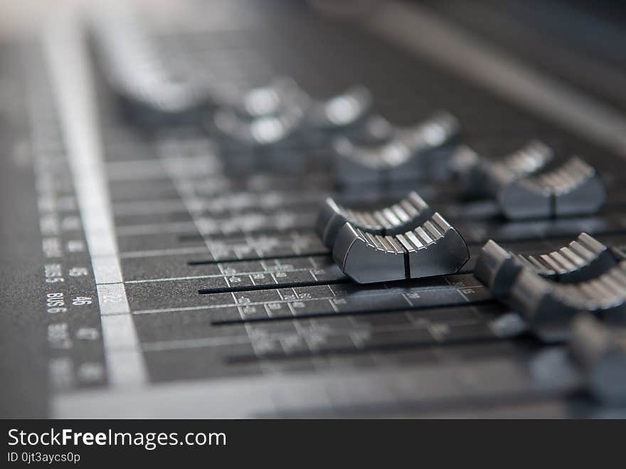 A industry studio mixing console. Close up makro photo of volume faders in grey with soft bokeh background. A industry studio mixing console. Close up makro photo of volume faders in grey with soft bokeh background.