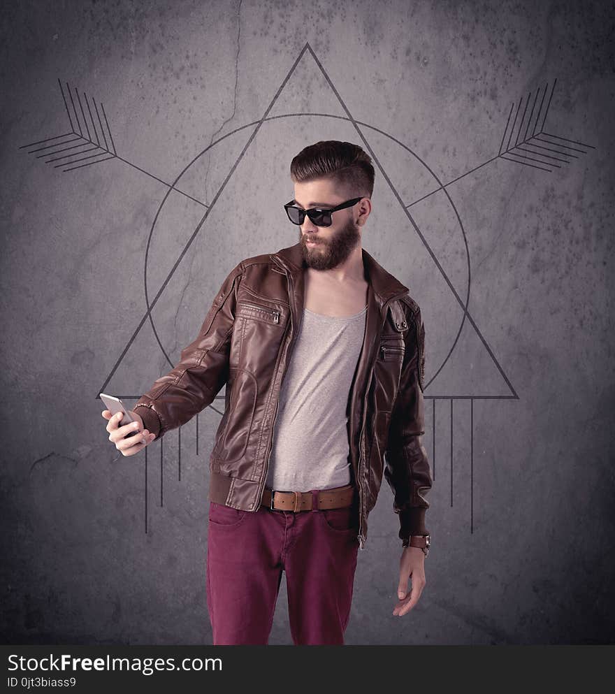 A young hipster male in modern clothes standing in front of an urban wall with modern sign illustration concept. A young hipster male in modern clothes standing in front of an urban wall with modern sign illustration concept