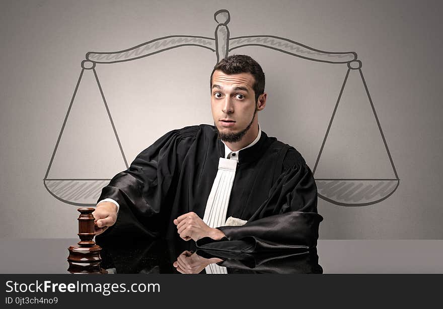 Young handsome judge in black gown making decision. Young handsome judge in black gown making decision