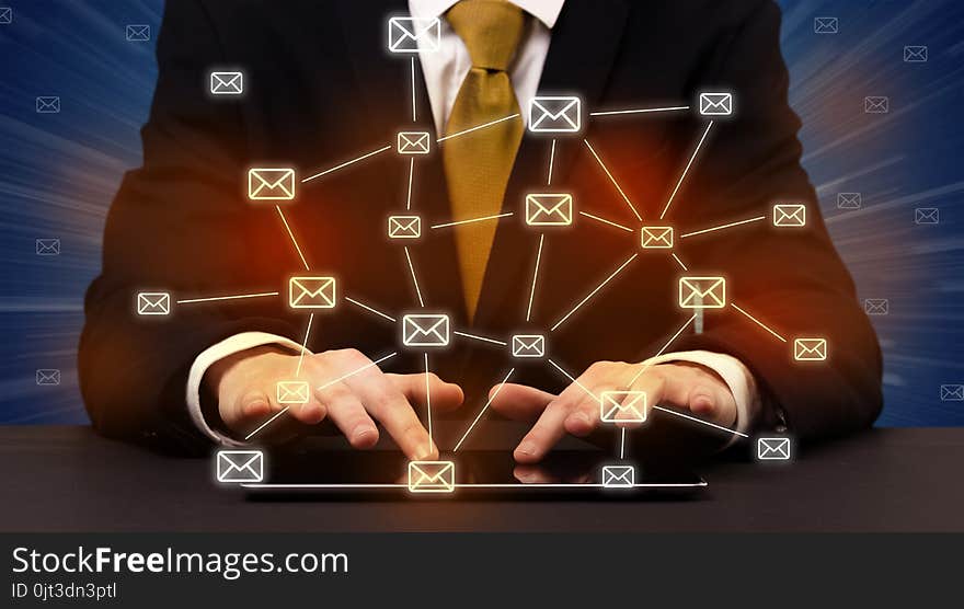 Businessman in suit typing with connected mail icons around. Businessman in suit typing with connected mail icons around