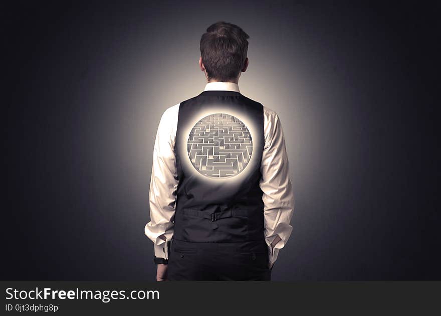 Businessman standing and thinking with maze graphic on his back. Businessman standing and thinking with maze graphic on his back