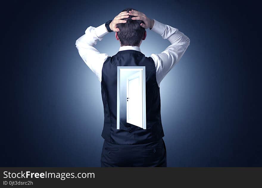 Young businessman standing and thinking with an open door on his back. Young businessman standing and thinking with an open door on his back