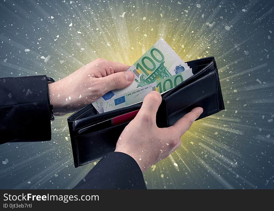 Businessman hand takes out dollar from wallet with fireworks and grungy background. Businessman hand takes out dollar from wallet with fireworks and grungy background