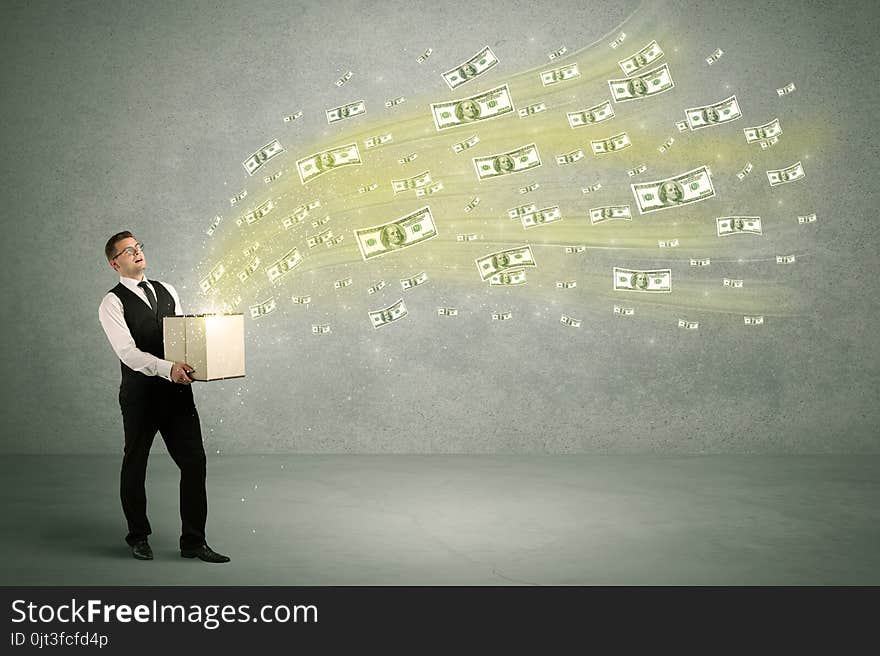 Successful young sales person making a lot of money concept illustrated with euro dollar bills flying out of a box held in his hand. Successful young sales person making a lot of money concept illustrated with euro dollar bills flying out of a box held in his hand.