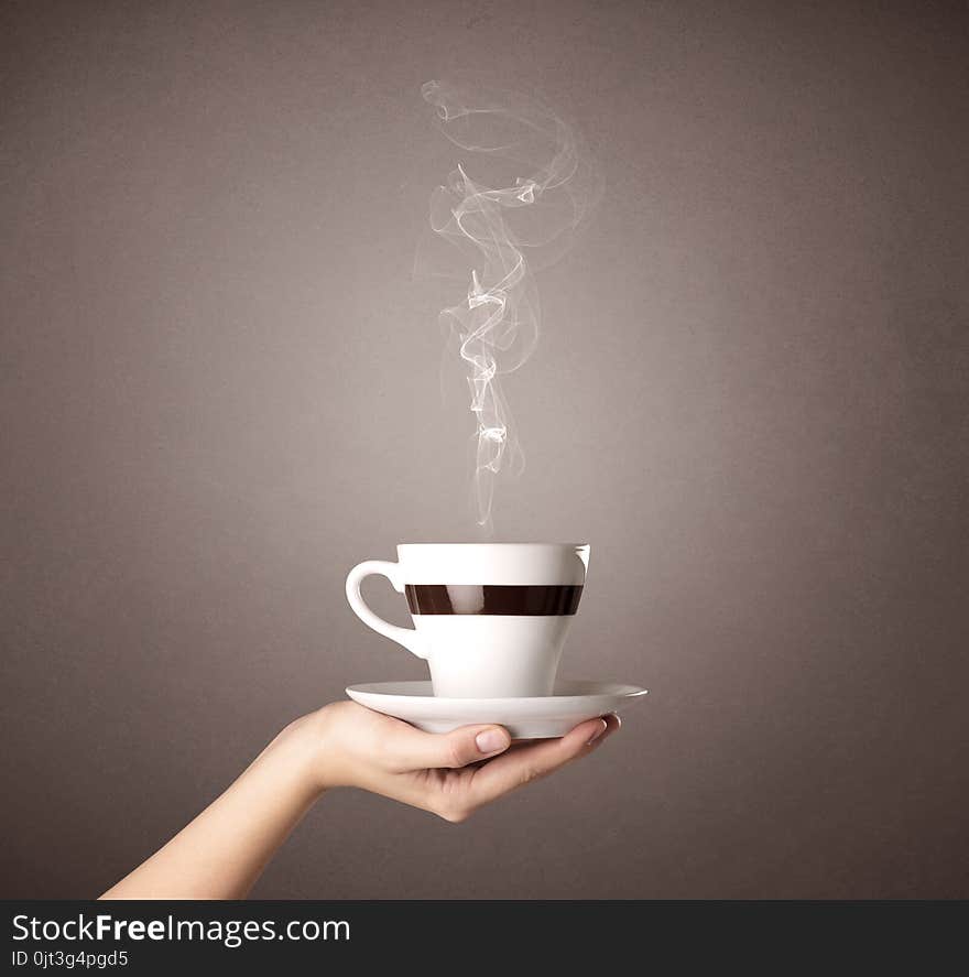 Young female hand holding steaming coffee cup. Young female hand holding steaming coffee cup