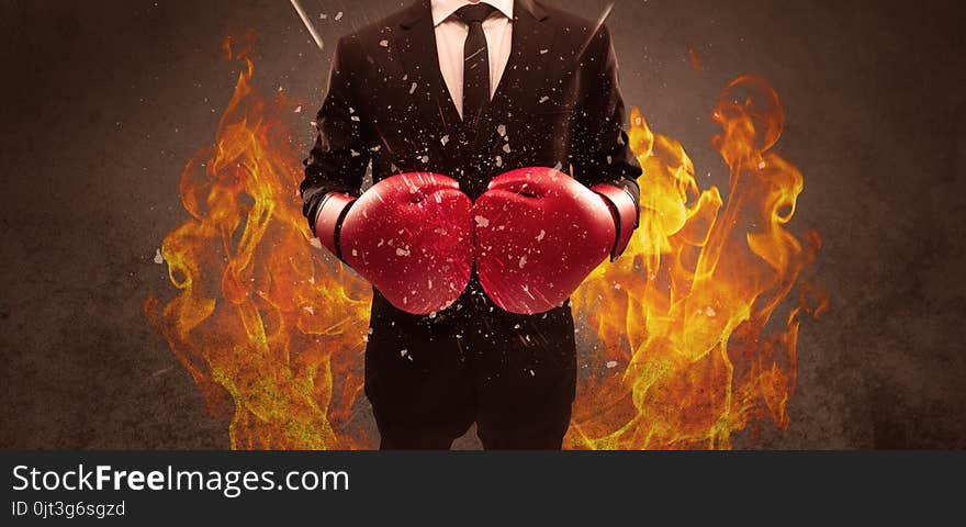 A strong sales person breaking something into pieces with red boxing gloves concept illustrated with glowing residue flying in the air. A strong sales person breaking something into pieces with red boxing gloves concept illustrated with glowing residue flying in the air.