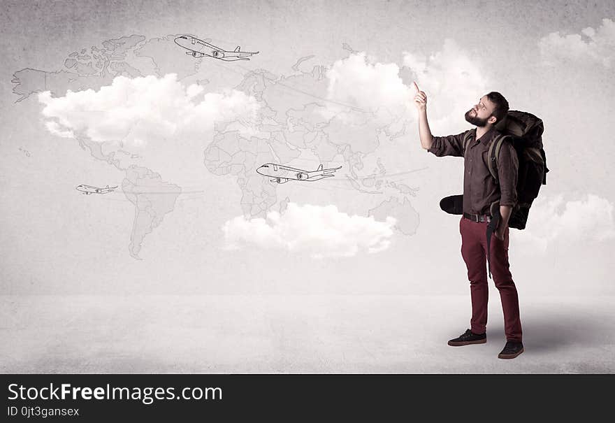 Handsome young man standing with a backpack on his back and planes in front of a world map as a background. Handsome young man standing with a backpack on his back and planes in front of a world map as a background