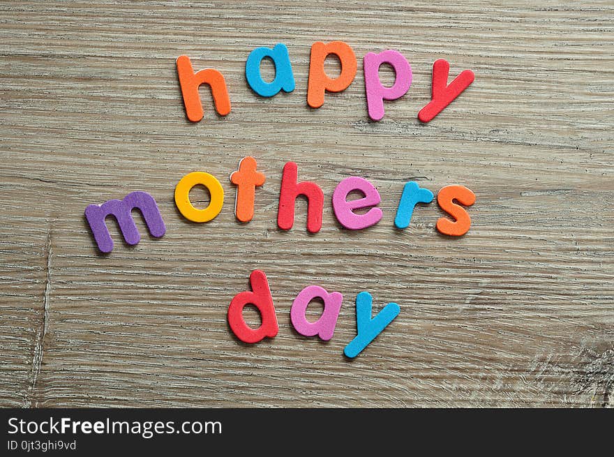 Happy mothers day in colorful letters on a wooden background