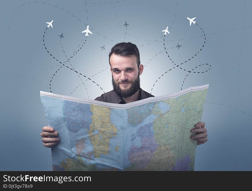 Handsome young man holding a map with little planes and their paths above him. Handsome young man holding a map with little planes and their paths above him