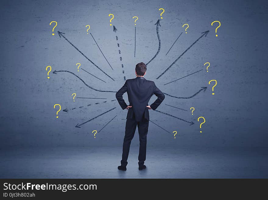 Businessman standing in front lines and question mark signs concept on background