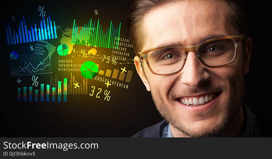 Portrait of a young businessman with colorful charts and graphs next to him on a dark background. Portrait of a young businessman with colorful charts and graphs next to him on a dark background