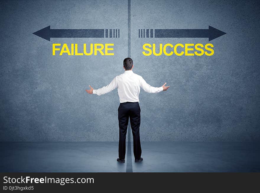 Businessman standing in front of success and failure arrow concept